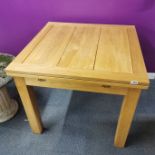 An extending light oak draw leaf kitchen table, unextended 90 x 90cm.