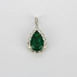 An 18ct white gold pendant set with a large pear cut emerald, approx. 2.41ct, L. 1.2cm, surrounded