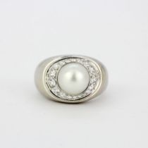 A heavy 18ct white gold 'De Beers' ring set with a cultured pearl surrounded by diamonds, (N).