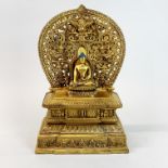 A Tibetan gilt bronze figure of a Buddhist altar, H. 28cm.