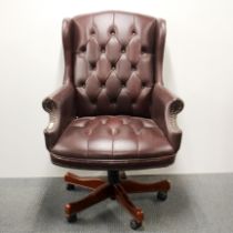 A faux leather adjustable button backed desk chair on wheels, H. 100cm.