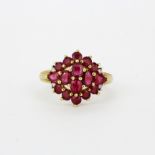 A hallmarked 9ct yellow gold ruby and diamond set cluster ring, (L).