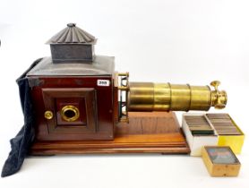A 19th century mahogany and brass magic lantern slide projector with an extensive collection of ...