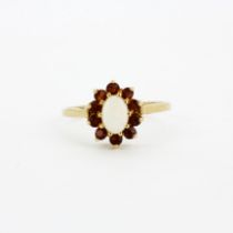 A hallmarked 9ct yellow gold (worn hallmark) cluster ring set with an oval cut opal surrounded by
