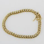 A 14ct yellow gold diamond set bracelet, approx. 2ct total, internal dia. 9cm.