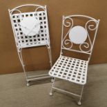 A pair of folding metal, painted garden chairs, folded H. 96cm together with a garden table.