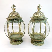 A pair of metal and glass garden storm lanterns, H. 50cm.