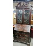 A stained and carved hardwood bureau cabinet, H. 246cm L. 95cm.
