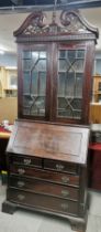 A stained and carved hardwood bureau cabinet, H. 246cm L. 95cm.