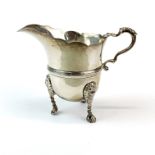 A heavy hallmarked silver cream jug with lion head and paw feet, H. 10cm.