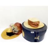 An early 20th century hat box and three hats.