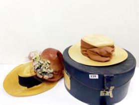 An early 20th century hat box and three hats.