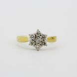 An 18ct yellow gold diamond set daisy cluster ring, approx. 0.75ct total, (L).