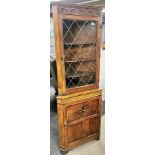 A carved oak corner cabinet with large single cupboard, H. 183cm W. 67cm.