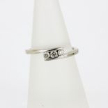A hallmarked 9ct white gold cross over rings set with three brilliant cut diamonds, (L.5).