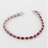 An 18ct white gold bracelet set with oval cut rubies and diamonds, approx. 0.61ct, L. 18.5cm.