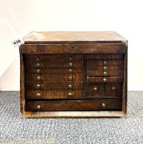 A 1930's oak cabinet of small drawers and tool contents. 35 x 27 x 19cm.