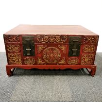 A Chinese chest on stand with gilt relief decoration and cast iron handles, overall 90 x 60 x 46cm.