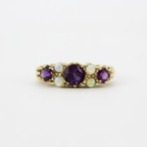 An Edwardian 9ct yellow gold ring set with amethysts and opals, (P.5).