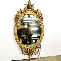 A gilt wood and gesso oval framed girandole mirror with three candle branches, 108 x 55cm.