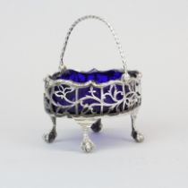 A heavy pierced hallmarked silver salt basket with blue glass liner, W. 9cm.