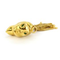 A heavy 14ct (stamped 14K) yellow gold pendant in the form of a woman's head, with green paste