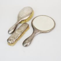 A three piece hallmarked silver dressing table set.