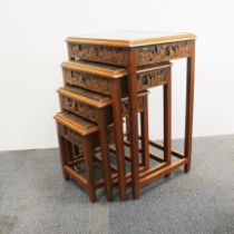 Nest of four oriental carved hardwood tables with plate glasses tops. Largest is 50 x 38 x 68cm.