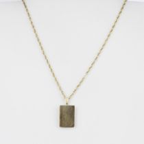 A hallmarked 9ct yellow gold book pendant on a yellow metal chain.