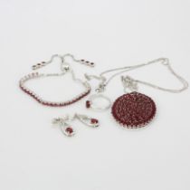 A suite of 925 silver and ruby jewellery, comprising a large pendant and chain, an adjustable