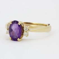 A 14ct (stamped 14K) yellow gold ring set with an oval cut amethyst and brilliant cut diamond