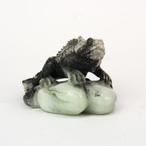 A finely carved Chinese mixed colour jade figure of a lizard on a rock. H. 7 W. 11 cms. Small damage