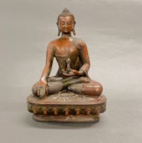 A Tibetan cast bronze figure of the Buddha meditating holding a dorje, H. 30.5cm.