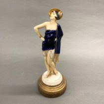 A 1930's porcelain figure of a girl on a brass plinth, H. 30cm.