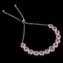 A 925 silver adjustable bracelet set with round cut rubies.