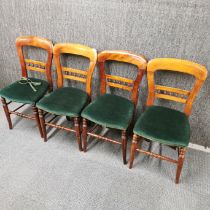 A set of four stained mahogany balloon backed dining chairs, H. 83cm.