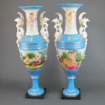 A pair of large continental porcelain vases decorated with Putti and with ornate handles, H. 51cm.