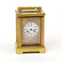 A miniature brass carriage clock with porcelain panels. H.7 cms.