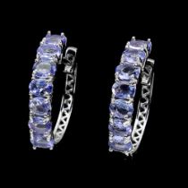 A pair of 925 silver hoop earrings set with oval cut tanzanites, L. 1.9cm.