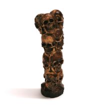 A hand carved antler in the form of twelve stacked human skulls.