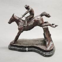 A cast bronze figure of a horse and jockey on a black and white marble base, L. 36cm, H. 32cm.