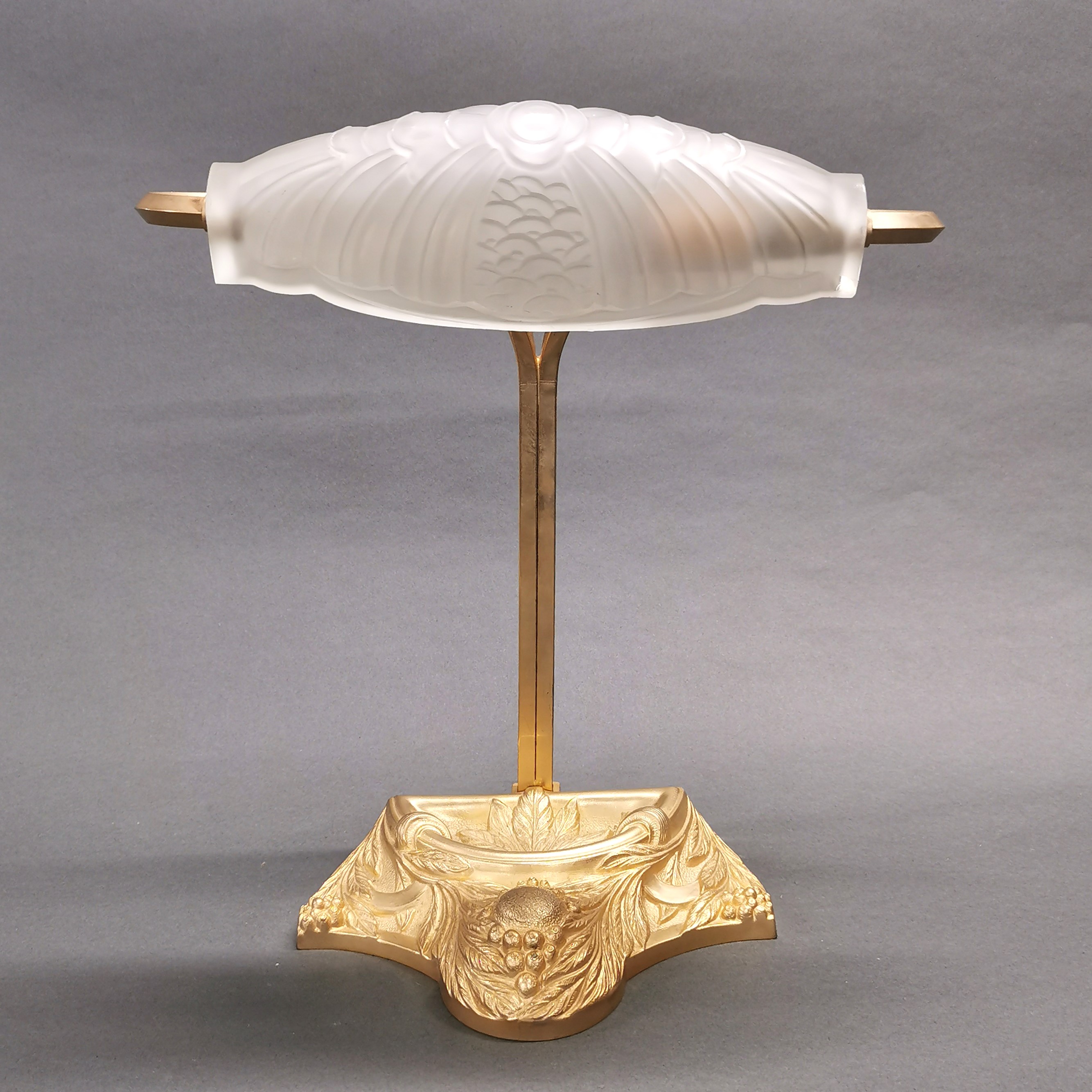 A frosted glass and gilt metal French desk lamp with relief decoration, H. 34cm.