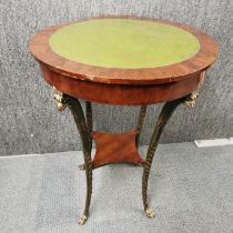 A two tier mahogany veneered and leather topped occasional table with gilt wood legs, H. 90cm Dia.