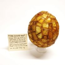 An antique ostrich egg, which has had approx. 150 specimens of copal (young amber) applied to it,
