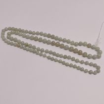 A pale celadon jade single string necklace of 9mm beads.