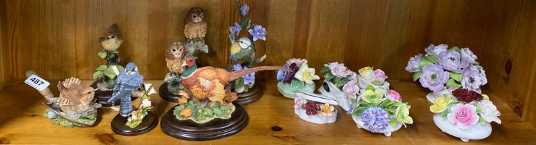 A group of six Country Artists bird figures with a group of porcelain posies.