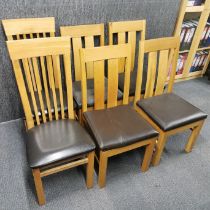 A set of four oak and faux leather dining chairs, together with a pair of similar dining chairs,
