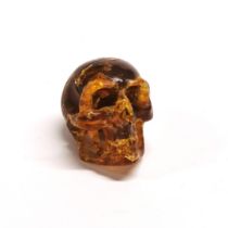 A hand carved amber human skull, originating from Indonesia and dating from the Miocene (approx.