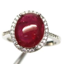 A 925 silver ring set with a large cabochon cut ruby surrounded by white stones, (N).