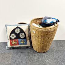 A linen basket with a quantity of linen and cushion.